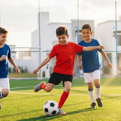 Niños jugando fútbol en la cancha de la privada
