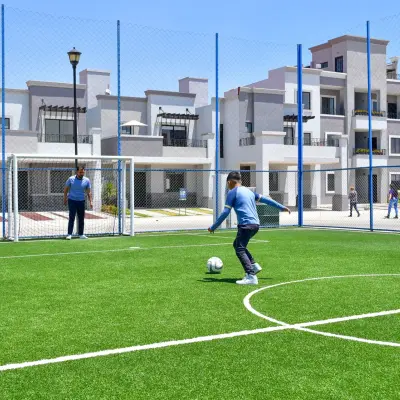 Cancha de fútbol de pasto sintético con portería y malla