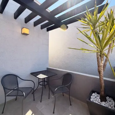 Balcón privado de la recámara principal de Molinara, con pérgola y juego de mesa