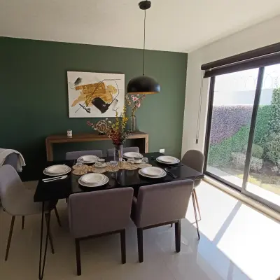 Comedor con mesa para seis y muro de acento verde