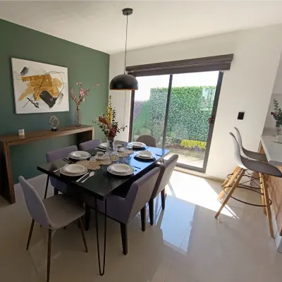 Comedor con vista al desayunador y salida al jardín
